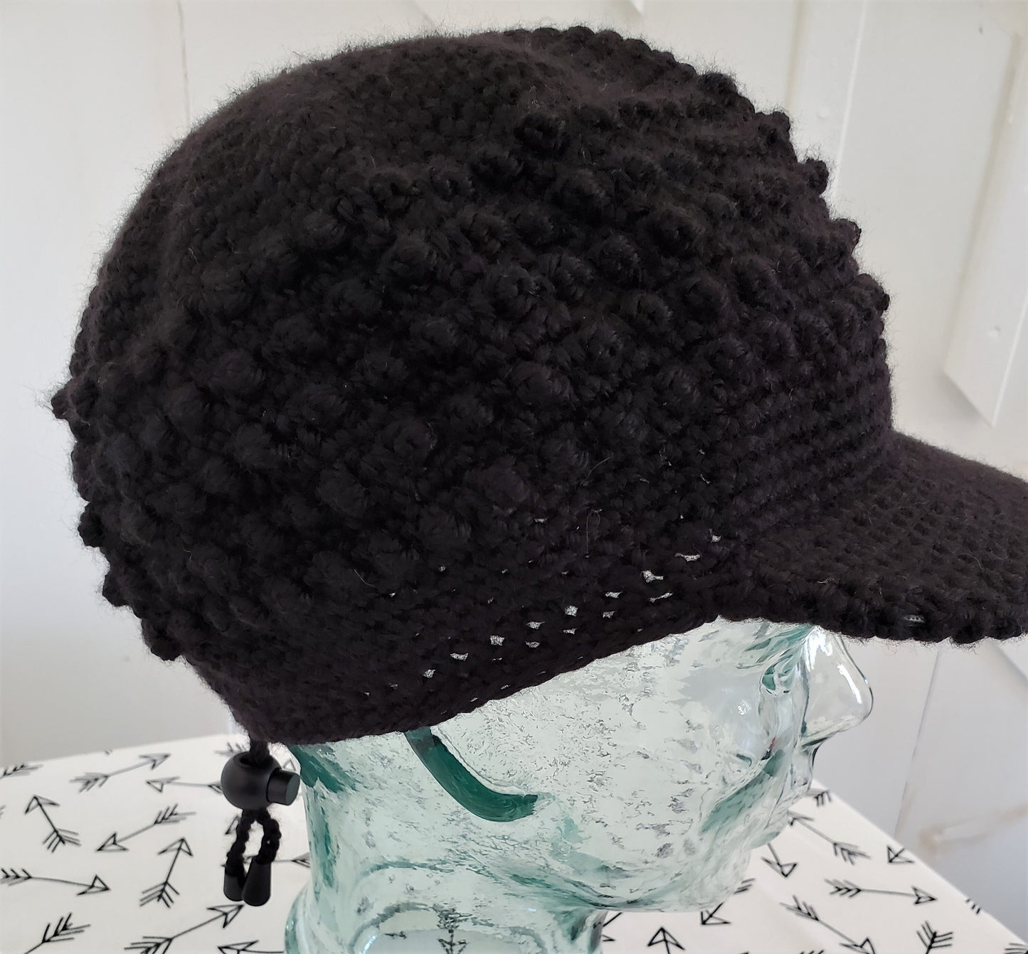 Black popcorn stitch cap with brim and toggle